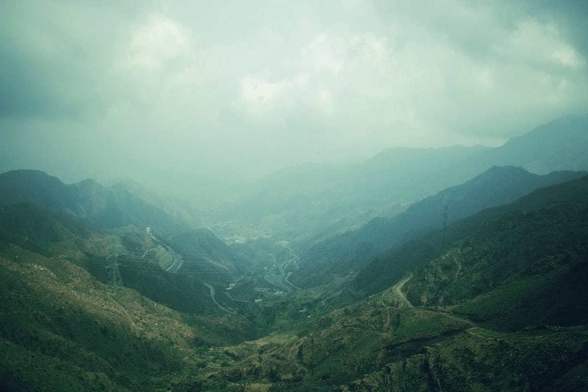 Green mountain valley with winding roads and misty hills in the Asir region near Abha