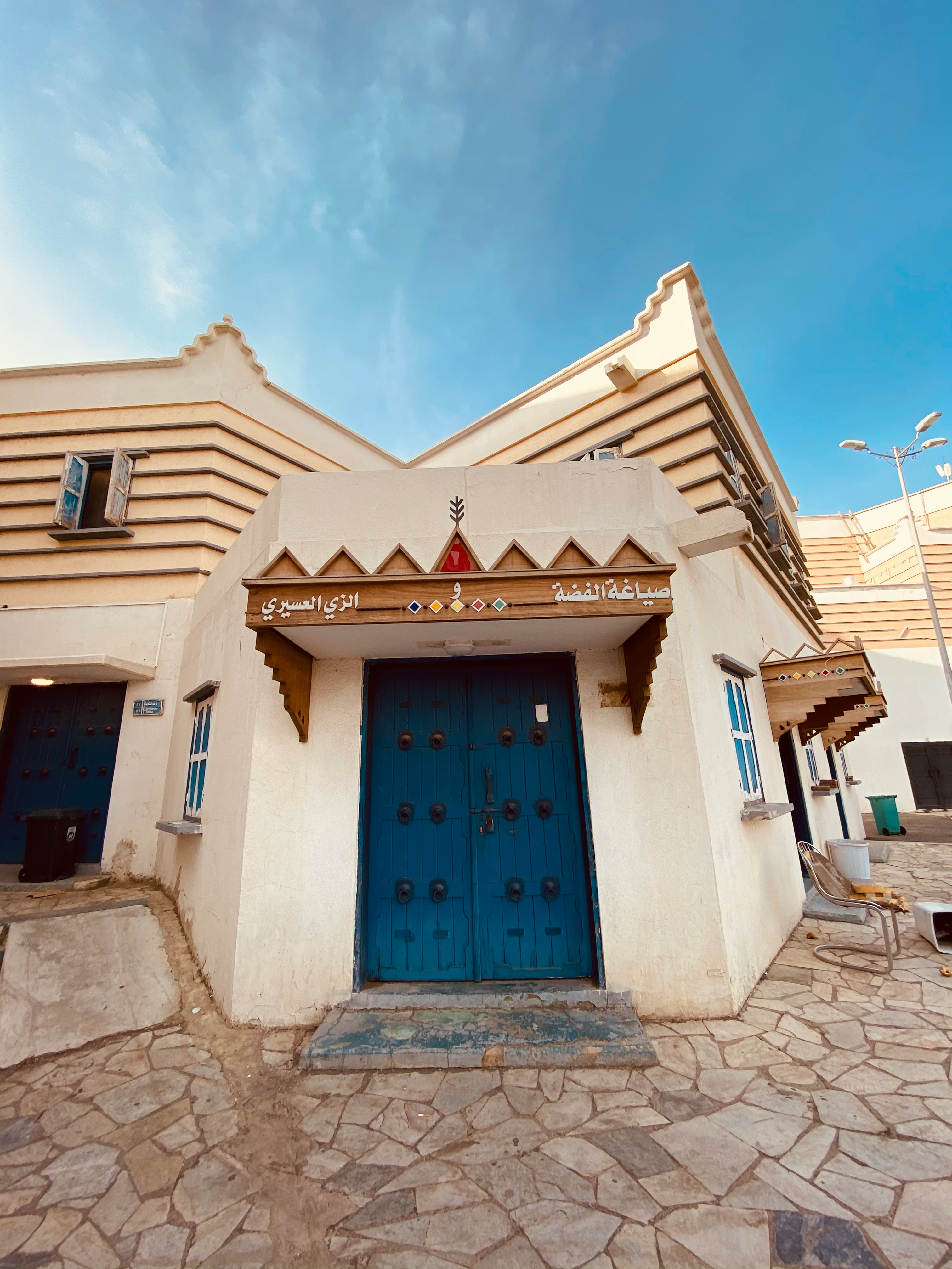 Traditional Asiri building with blue wooden door and geometric patterns, Abha, Saudi Arabia