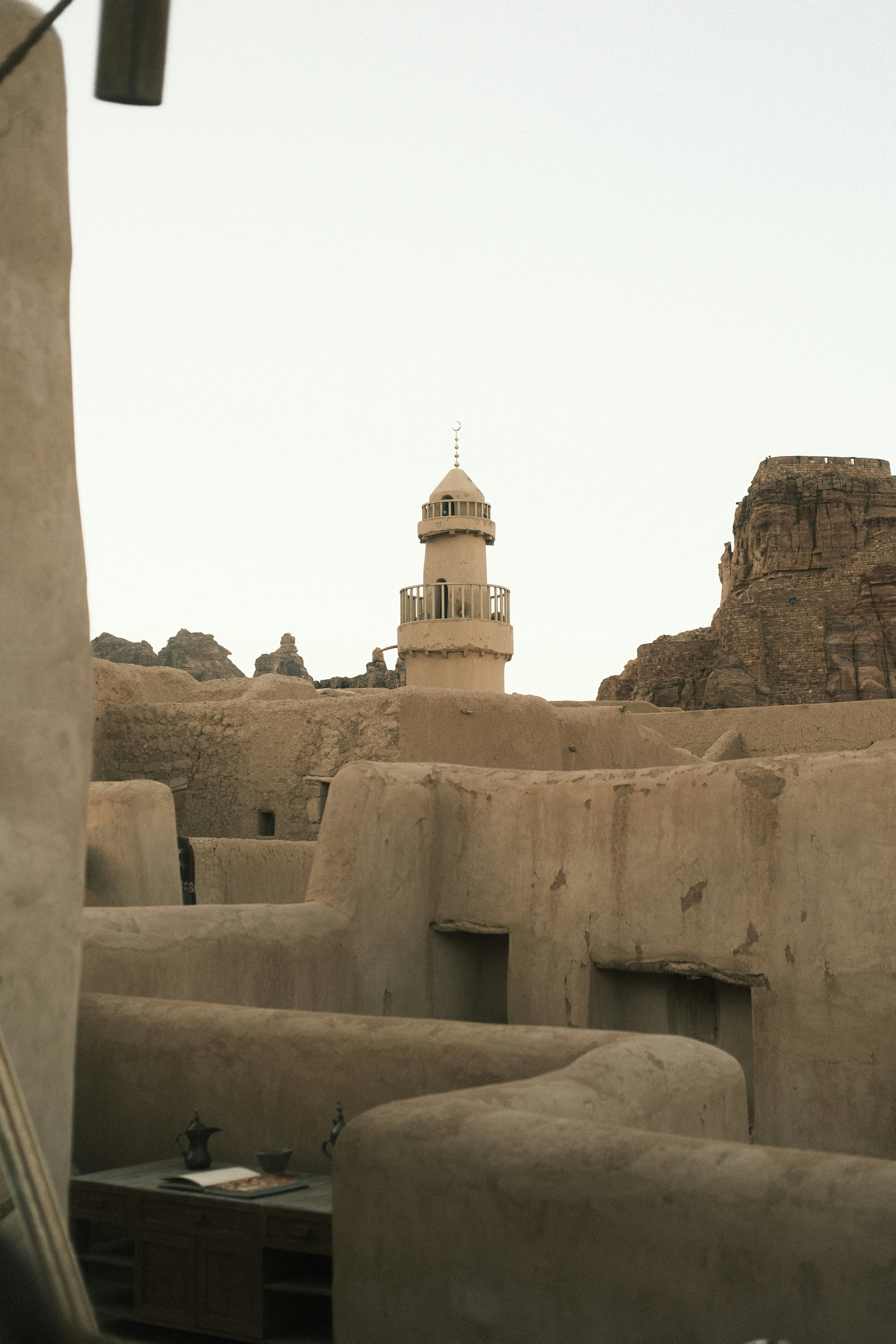 Minaret rising above ancient mud-brick buildings in AlUla Old Town, Saudi Arabia