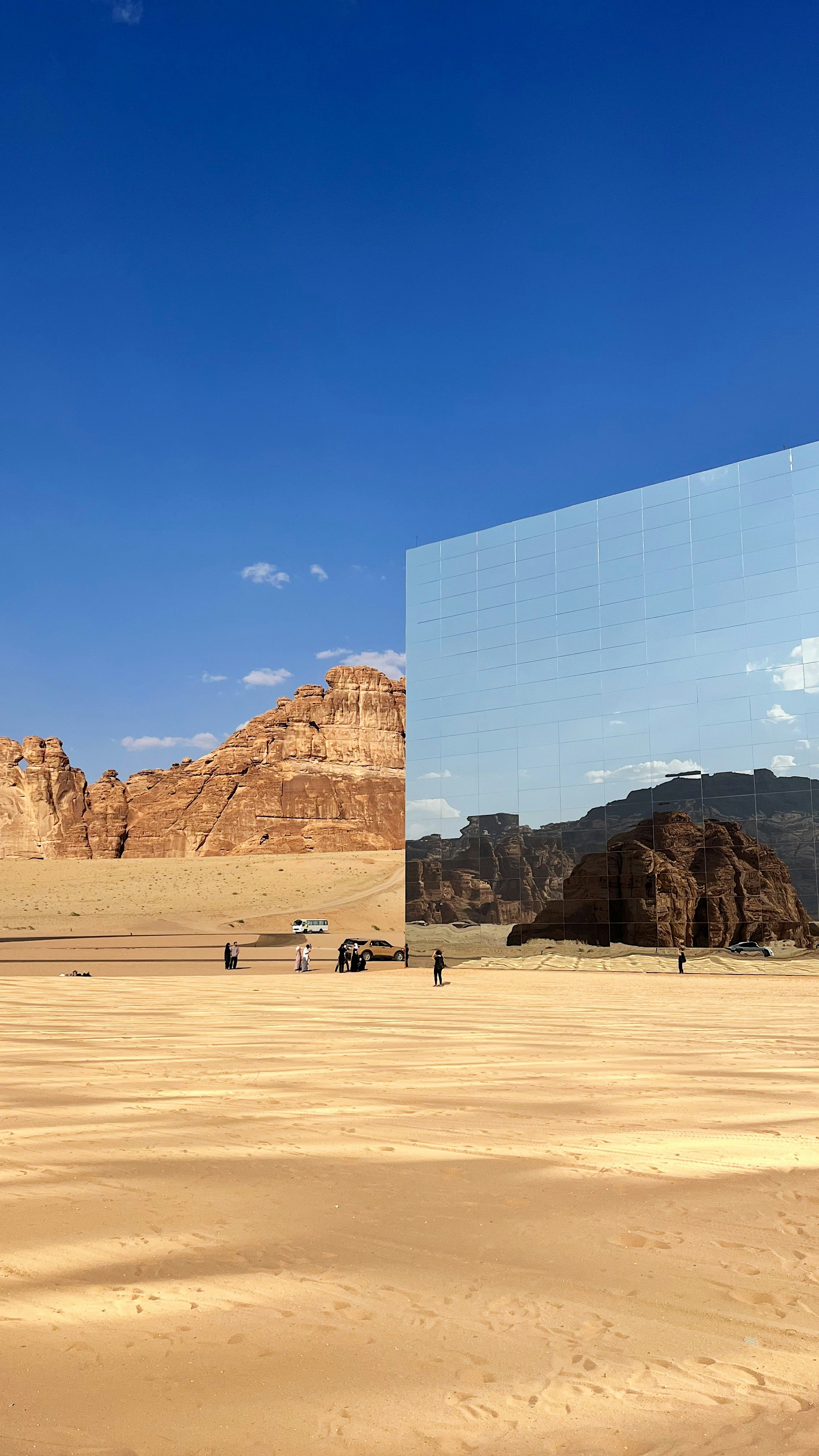 Maraya mirror concert hall reflecting sandstone cliffs and blue sky in the AlUla desert, Saudi Arabia