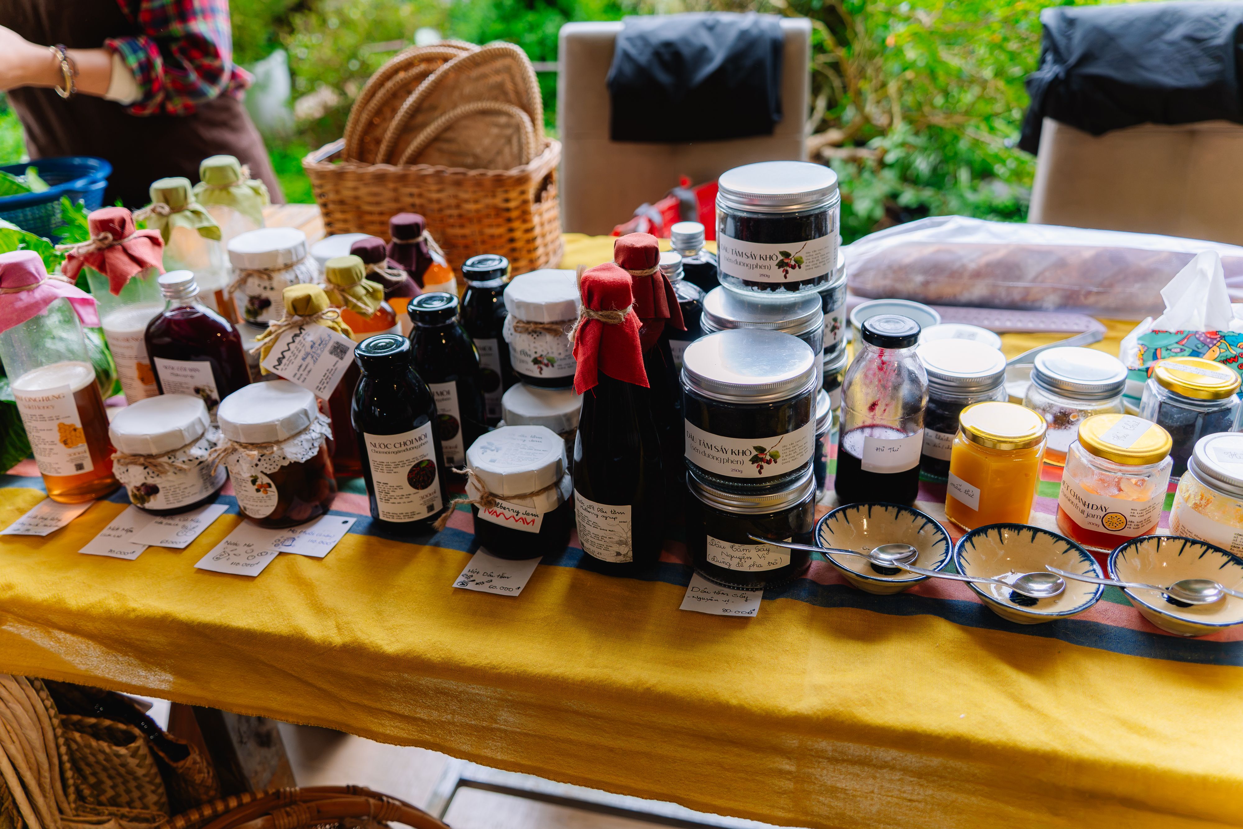 Artisan jars of preserves, syrups, and honey products displayed at an outdoor market stall