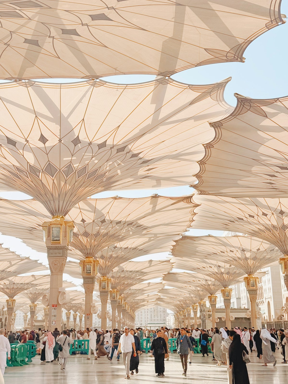 Pilgrims walking under large white shaded umbrella canopies at Al-Masjid an-Nabawi, Medina, Saudi Arabia