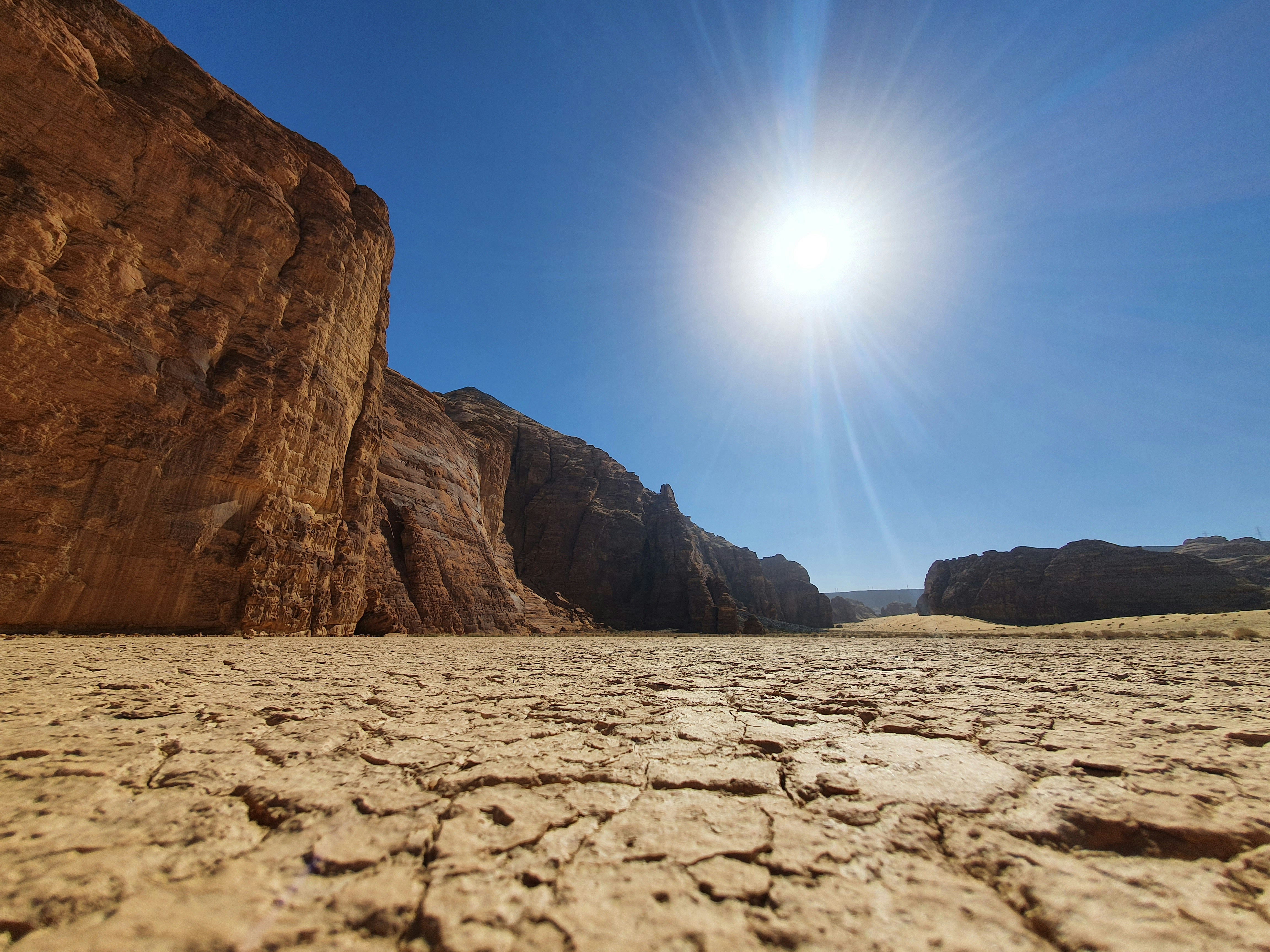 Red sandstone canyon formations under blazing sun, AlUla desert, Saudi Arabia