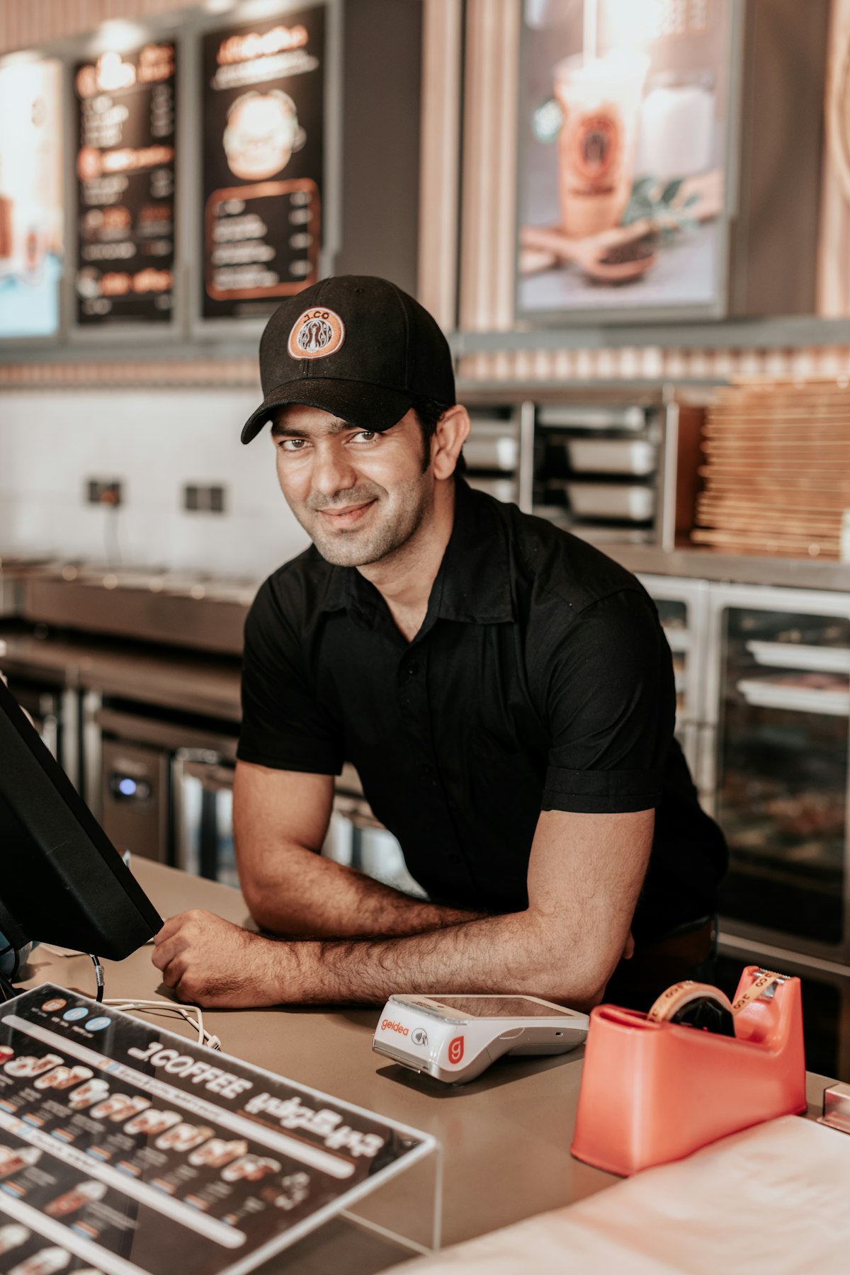 Barista at a coffee counter in a Riyadh café with menu boards and modern interior